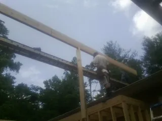 Carpenter setting a ridge beam over a new addition frame — Ice Dam Removal by Roofing Brothers in Nevada City