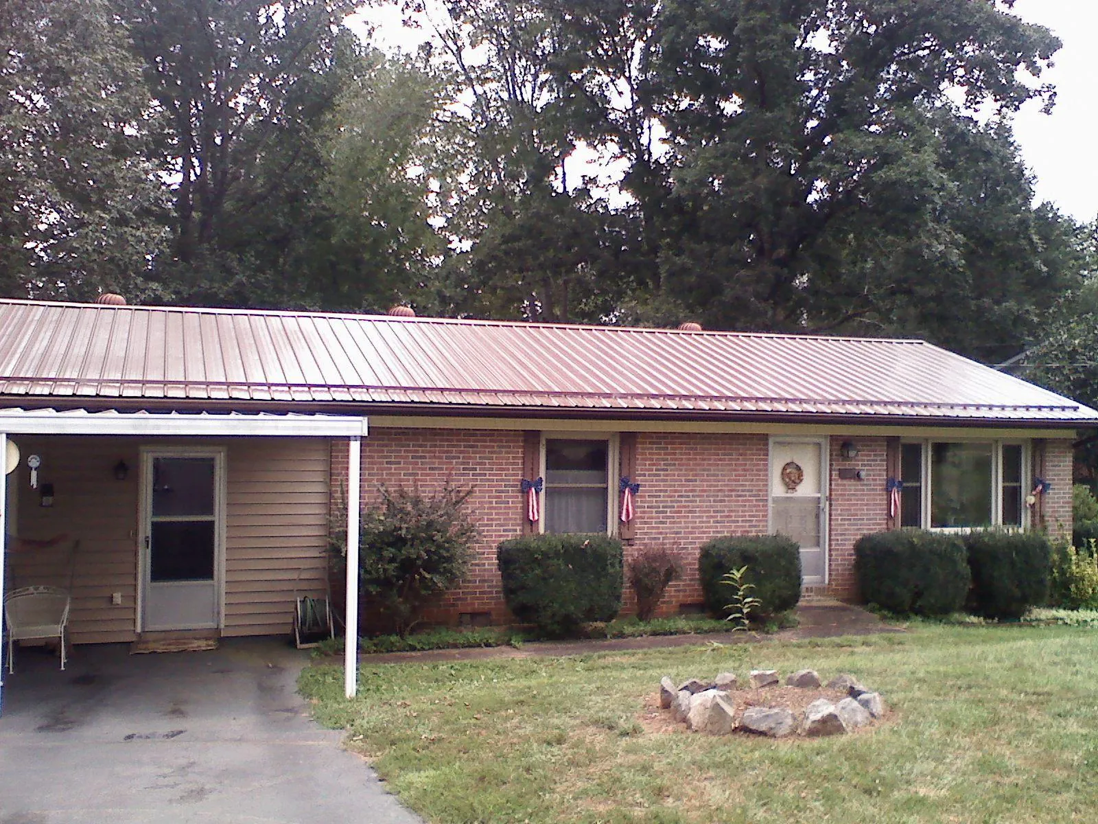 Bronze metal roof and carport on a brick ranch home — Roof Repair work by our crew in Nevada City